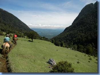 Reiterin den Berge mit Blick ins Pucon Tal beim Tagesritt